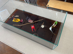 A tub that is filled with murky water and has debris in. Depicting the damage from a flooding event. 