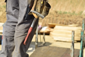 A person holding a tool in a buidling site 